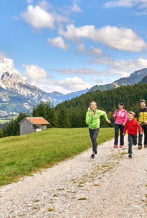 Familie läuft auf Weg in den Bergen, Hotel Tyrol am Haldensee