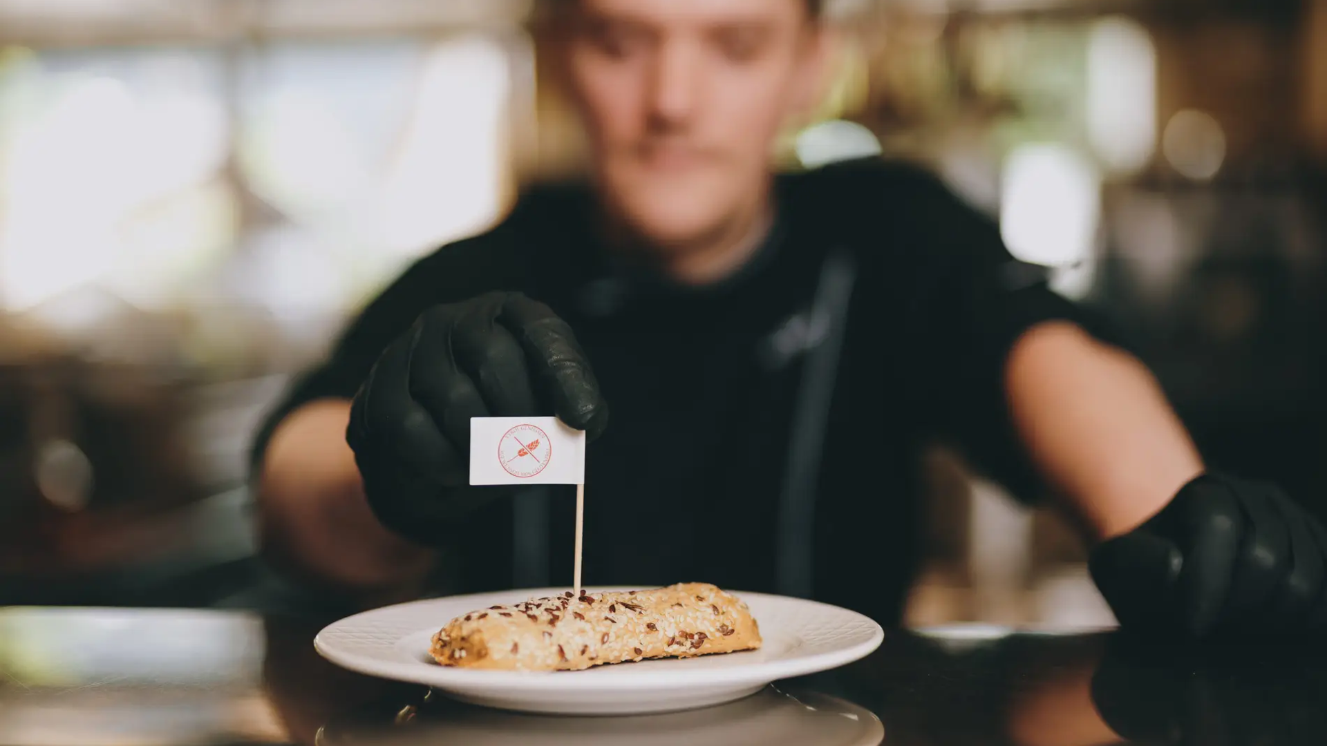 Koch präsentiert Gebäck mit Fähnchen im Hotel Tyrol