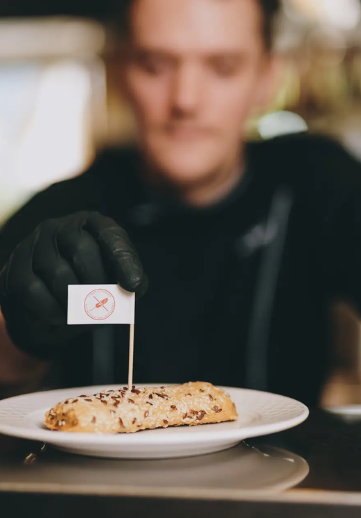 Koch präsentiert Gebäck mit Fähnchen im Hotel Tyrol