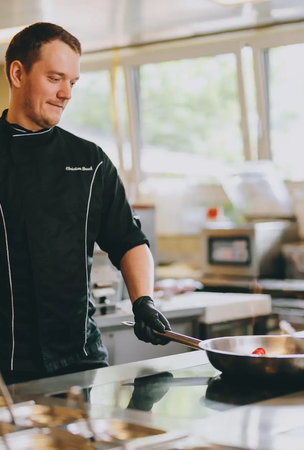 Koch brät in Pfanne in Hotel Tyrol Küche