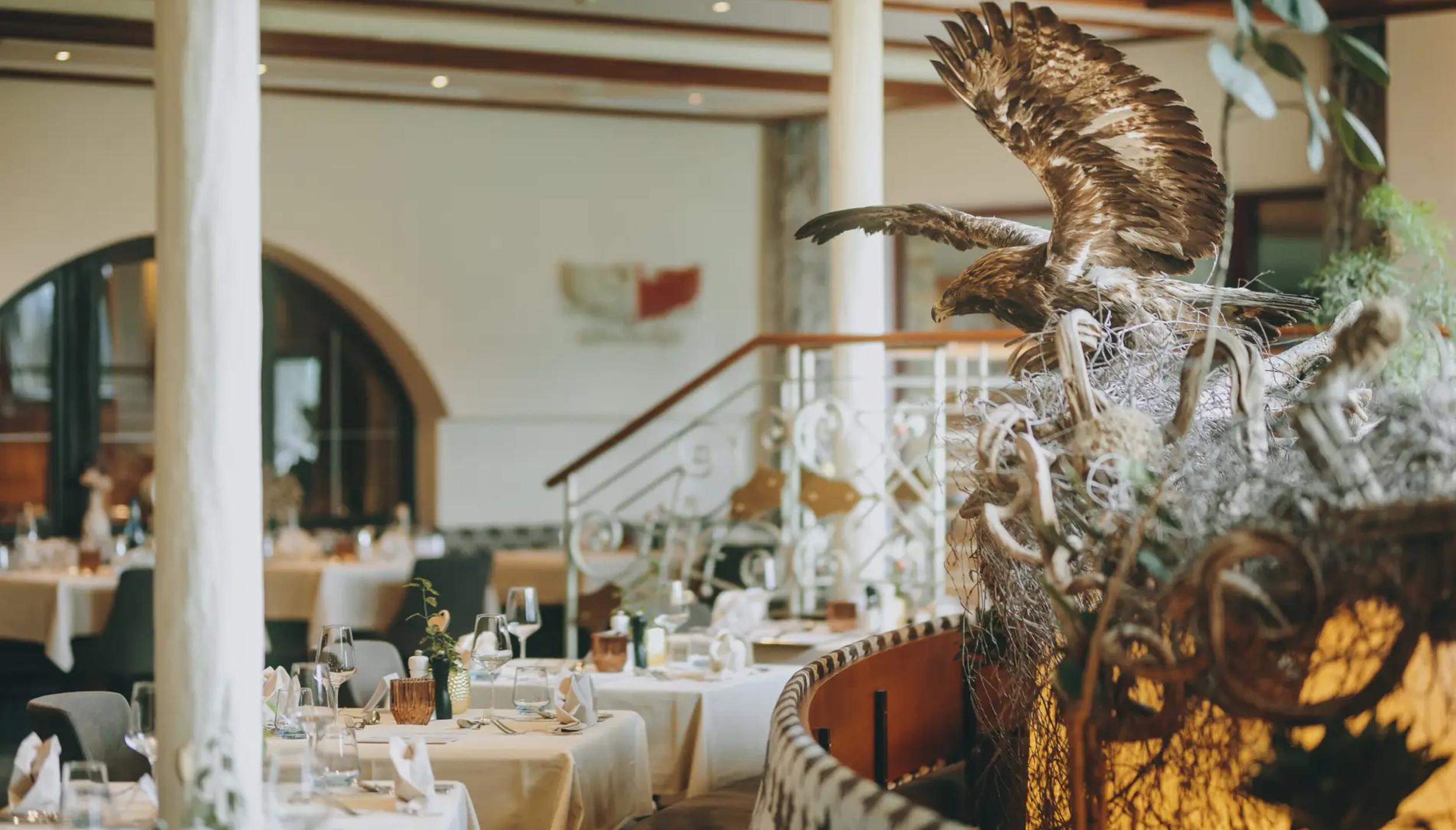 Hotel Tyrol: Restaurant mit Adler-Skulptur und gedeckten Tischen