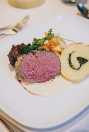 Teller mit Fleisch, Kartoffelrolle und Gemüse im Hotel Tyrol