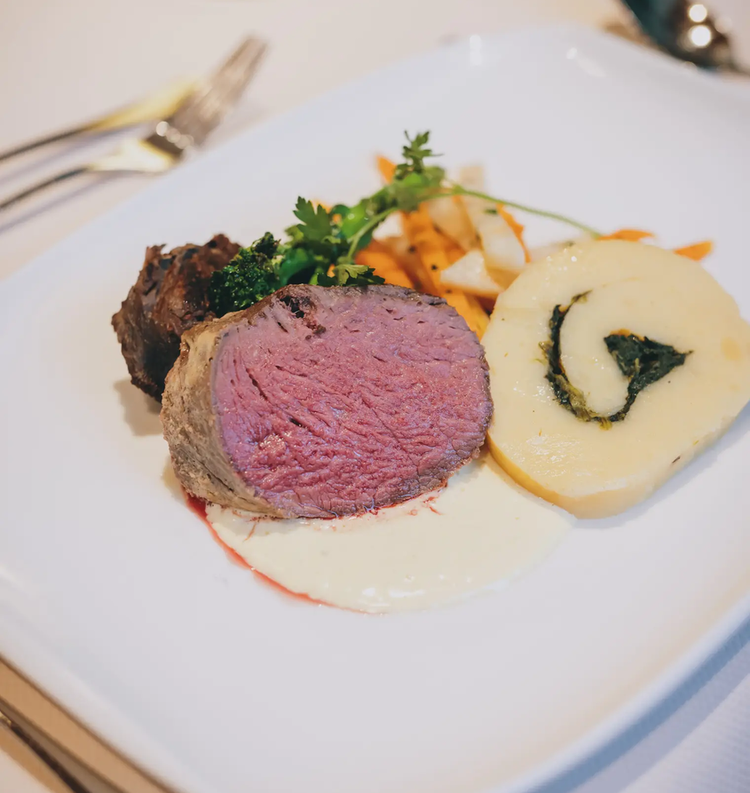 Teller mit Fleisch, Kartoffelrolle und Gemüse im Hotel Tyrol