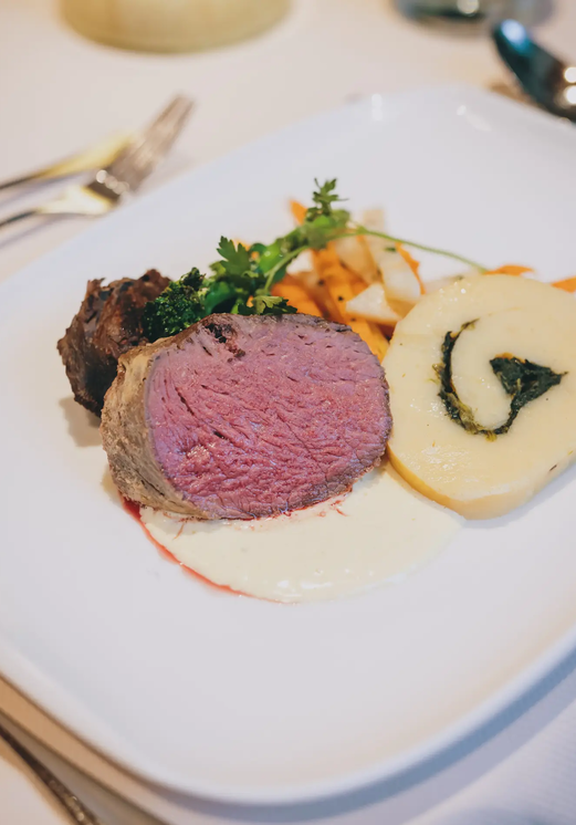 Teller mit Fleisch, Kartoffelrolle und Gemüse im Hotel Tyrol