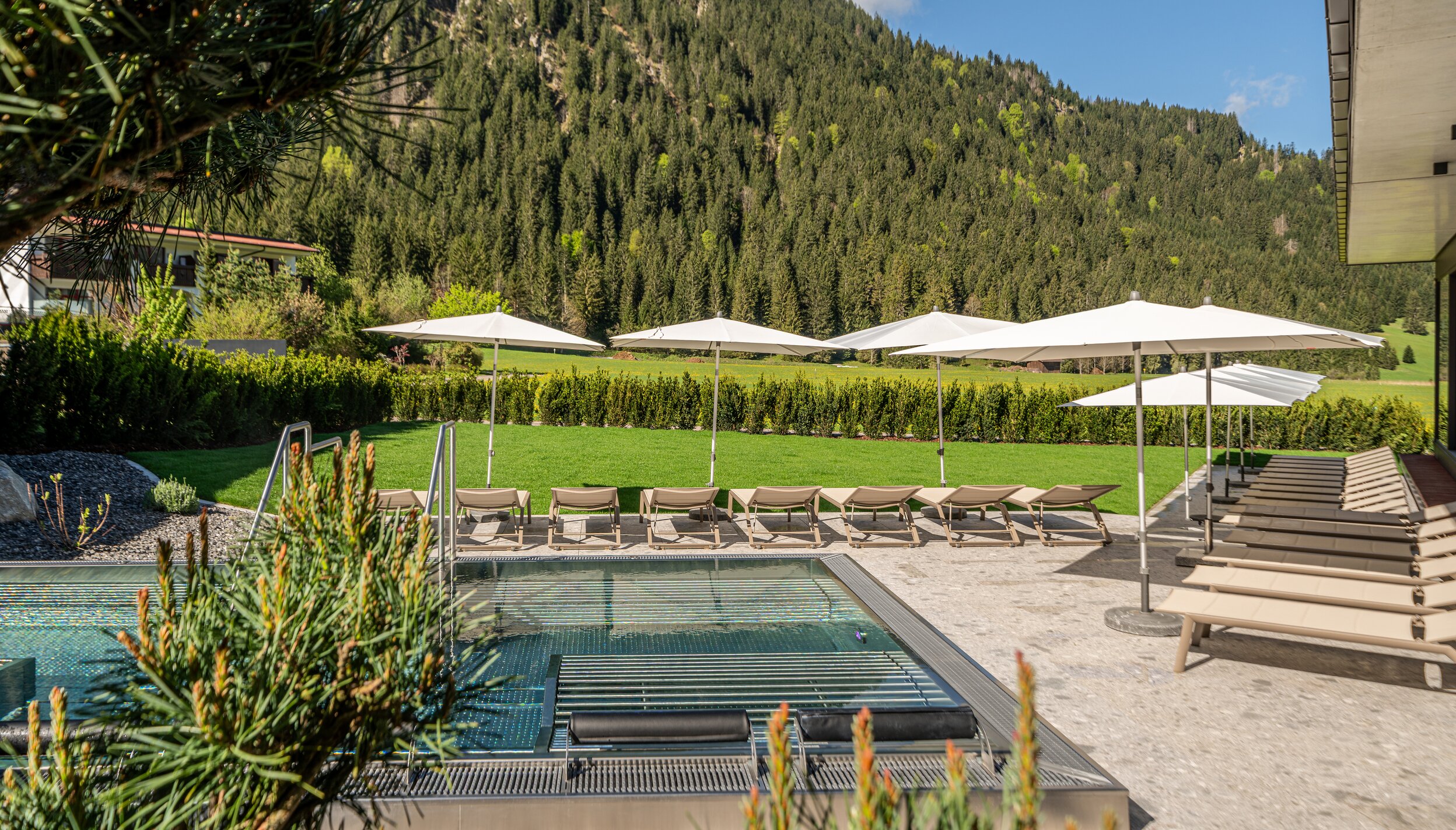 Whirlpool im Hotel Tyrol am Haldensee mit Liegen und Sonnenschirmen