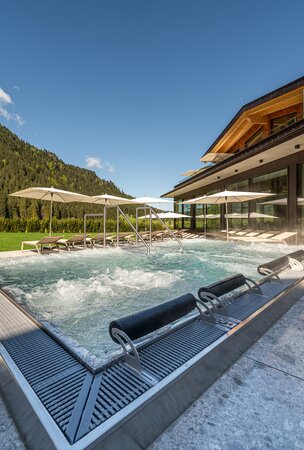 Whirlpool im Hotel Tyrol am Haldensee mit Liegen und Sonnenschirmen