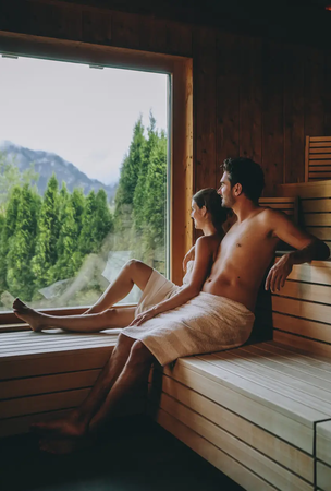 Paar in Sauna mit Blick auf Berge im Hotel Tyrol