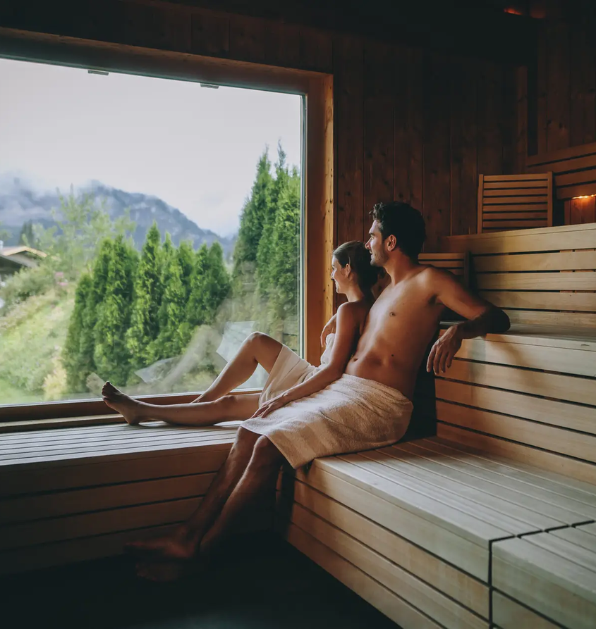 Paar in Sauna mit Blick auf Berge im Hotel Tyrol