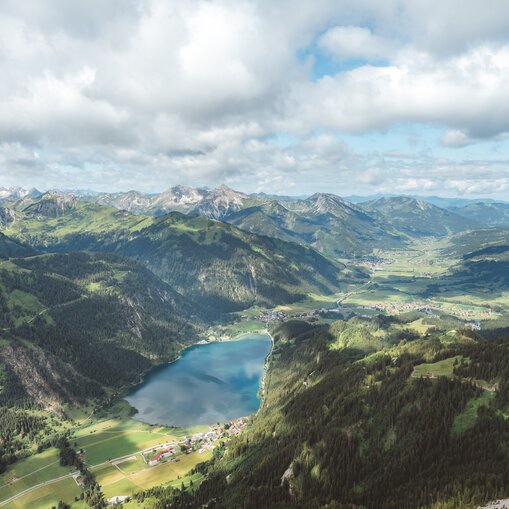Haldensee im Tannheimer Tal, umgeben von Bergen und Wolken