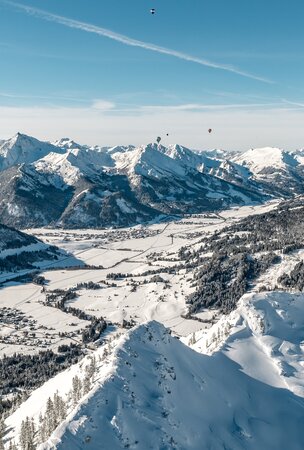 Winterliche Berglandschaft mit Ballonfestival am Haldensee in Tirol