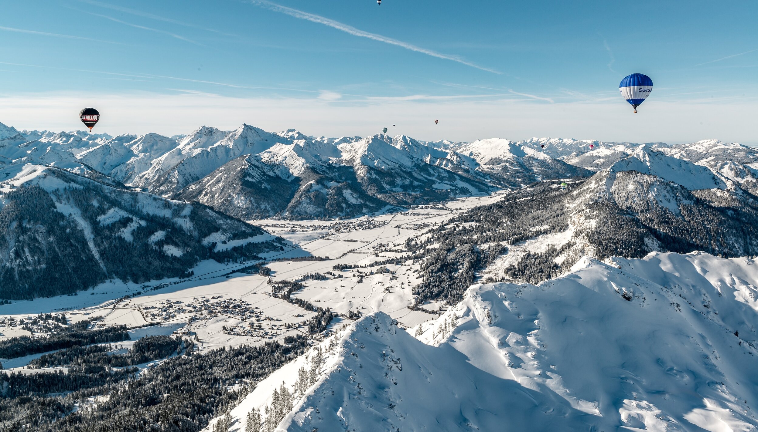 Winterliche Berglandschaft mit Ballonfestival am Haldensee in Tirol